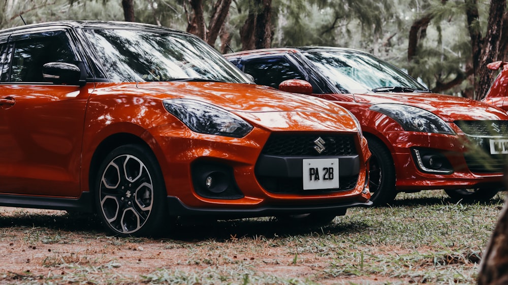 a row of orange cars parked in a forest
