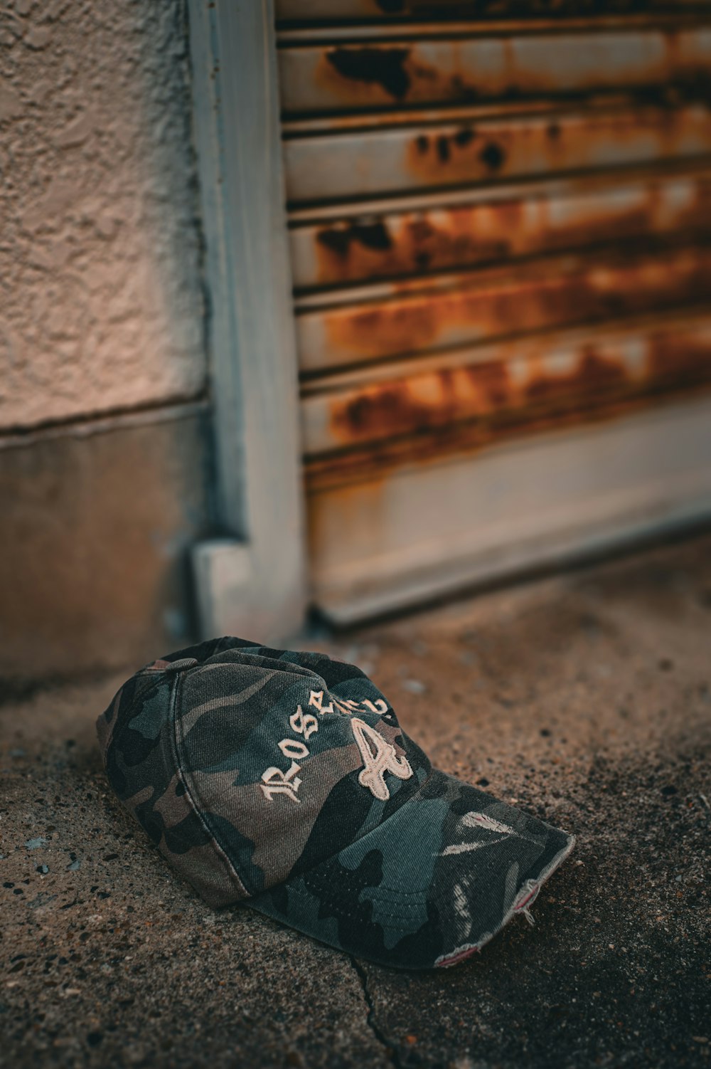 a camouflaged hat laying on the ground in front of a door