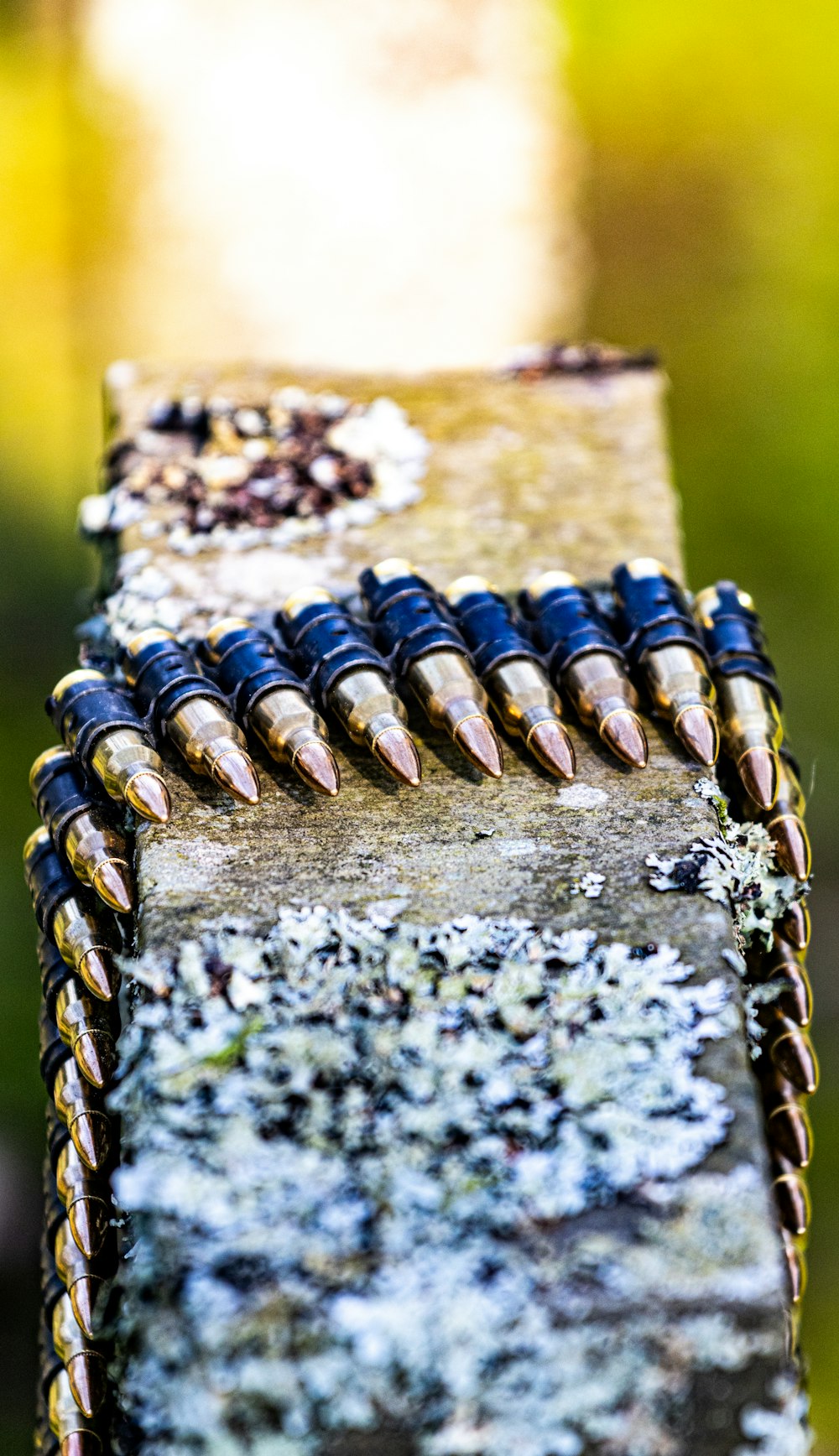 a bunch of bullet shells sitting on top of a piece of wood