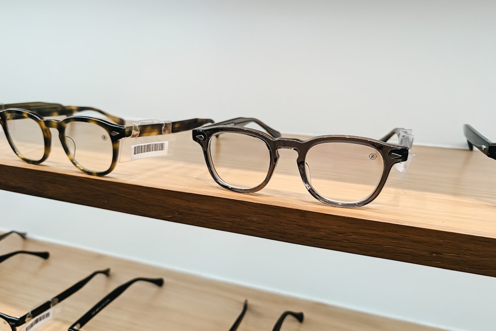 a pair of glasses sitting on top of a wooden shelf