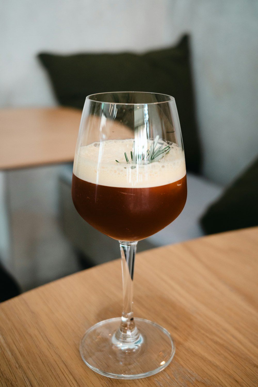 a glass filled with liquid sitting on top of a wooden table