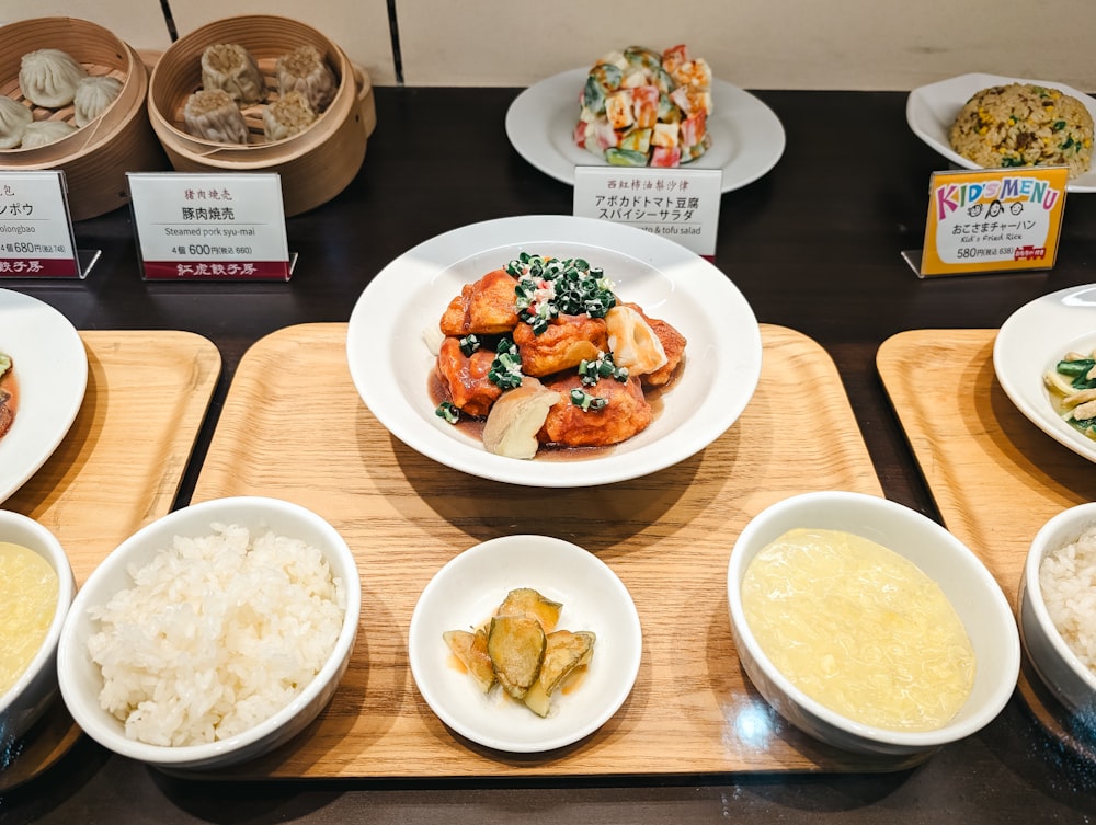 a table topped with plates of food and bowls of rice