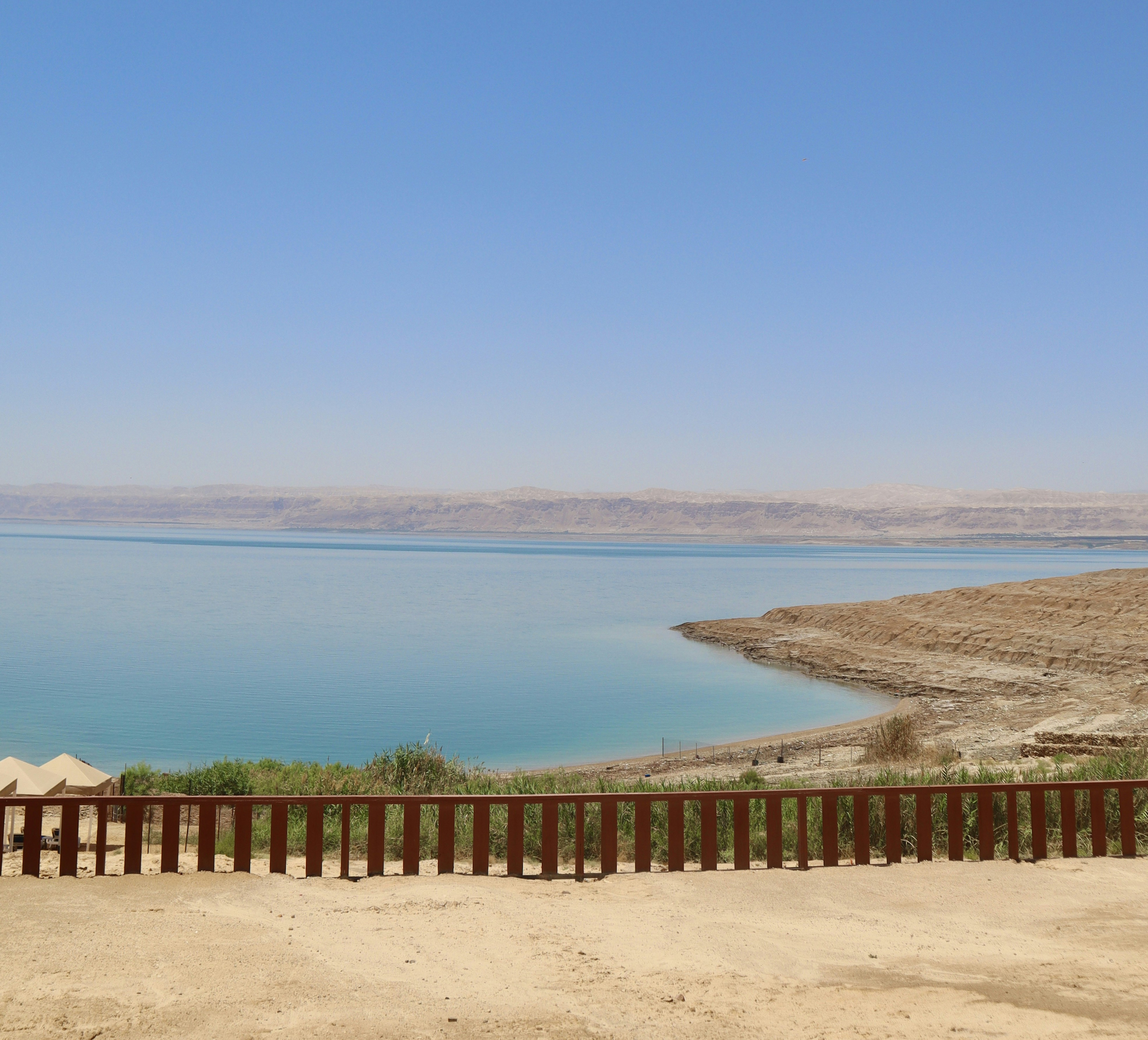 a bench sitting on top of a sandy beach