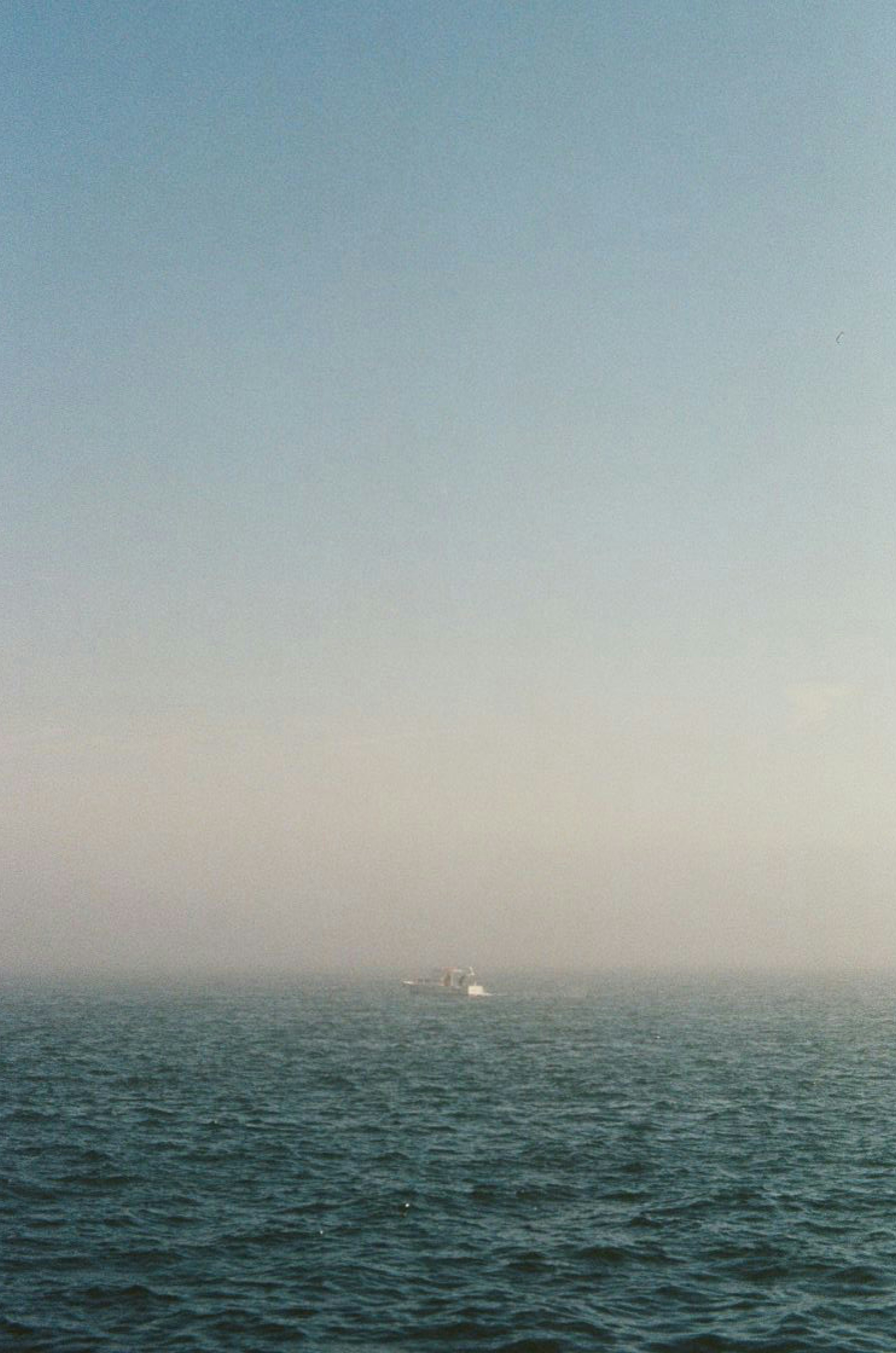 a large body of water with a boat in the distance