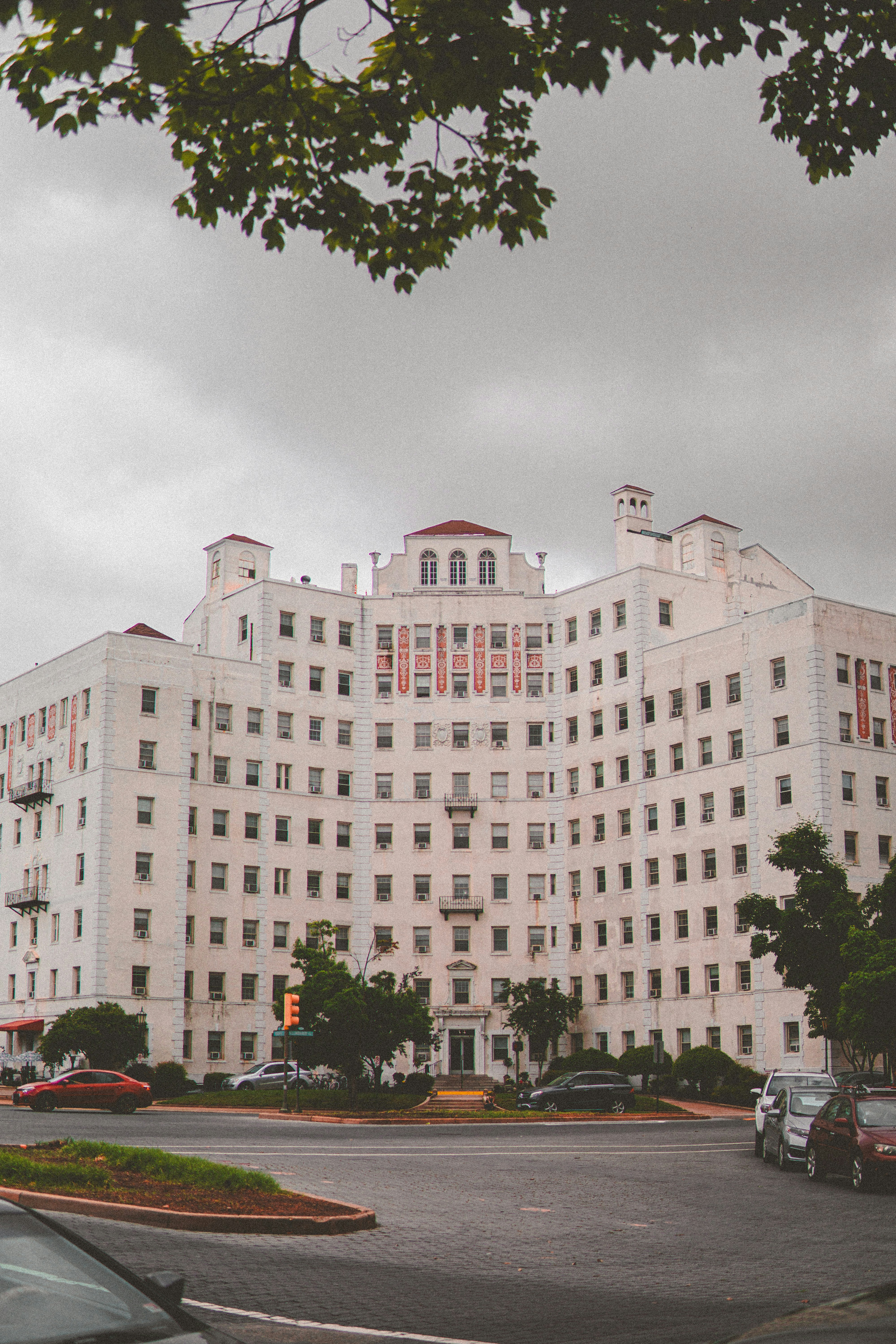 A large white building sitting on the side of a road photo – Free Car ...