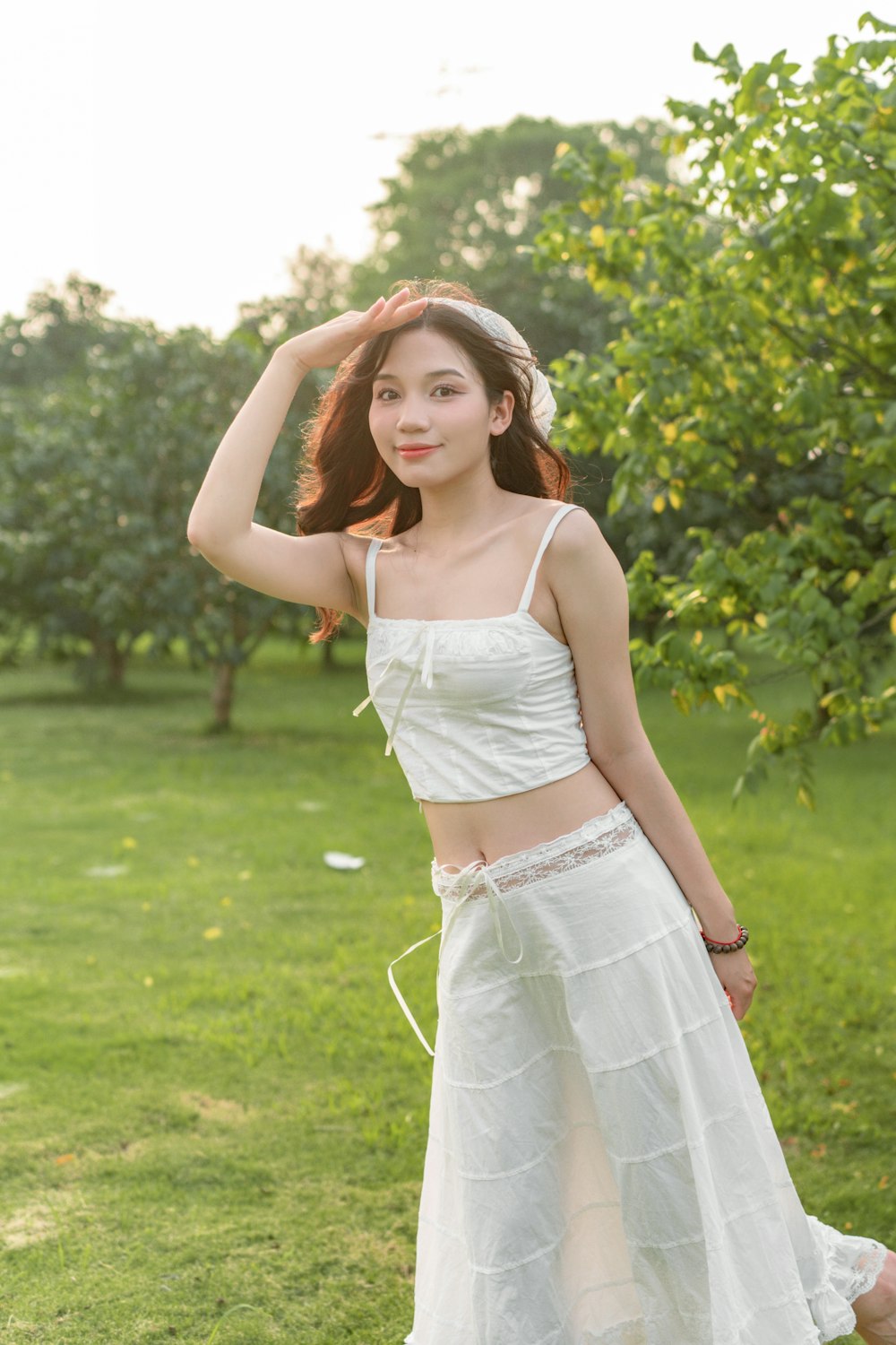 a woman in a white dress standing in the grass