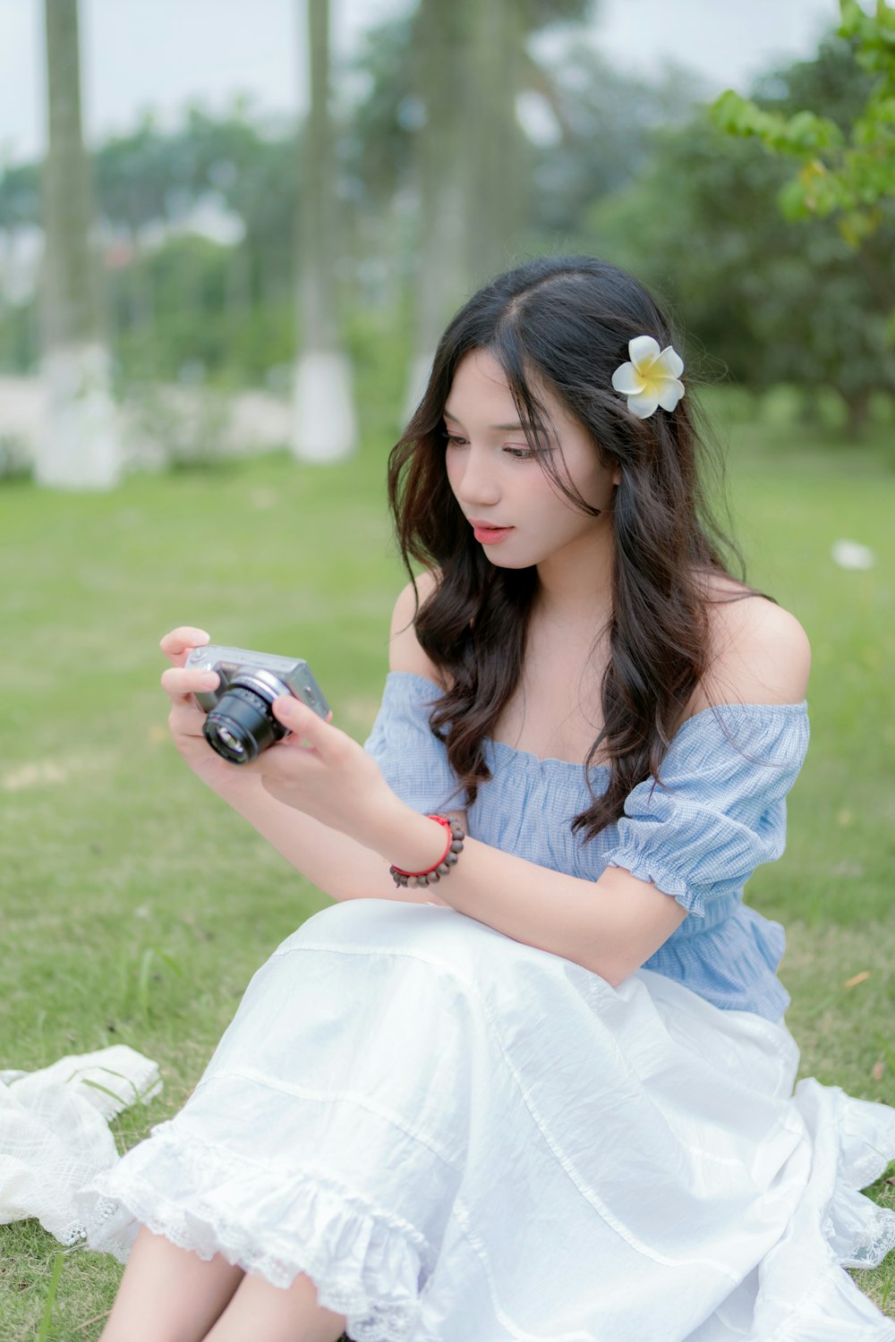 a woman sitting on the ground holding a camera