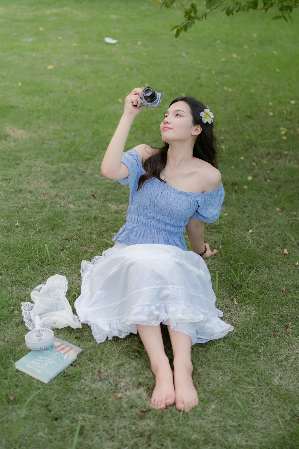 a woman in a blue dress sitting on the grass