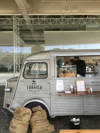 A compact mobile food and coffee trailer parked in a lot