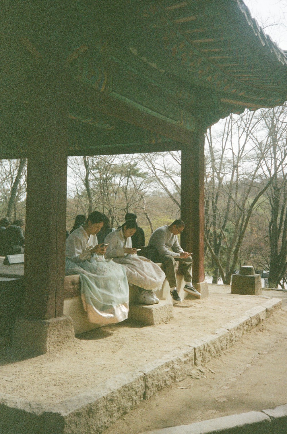 a group of people sitting under a wooden structure