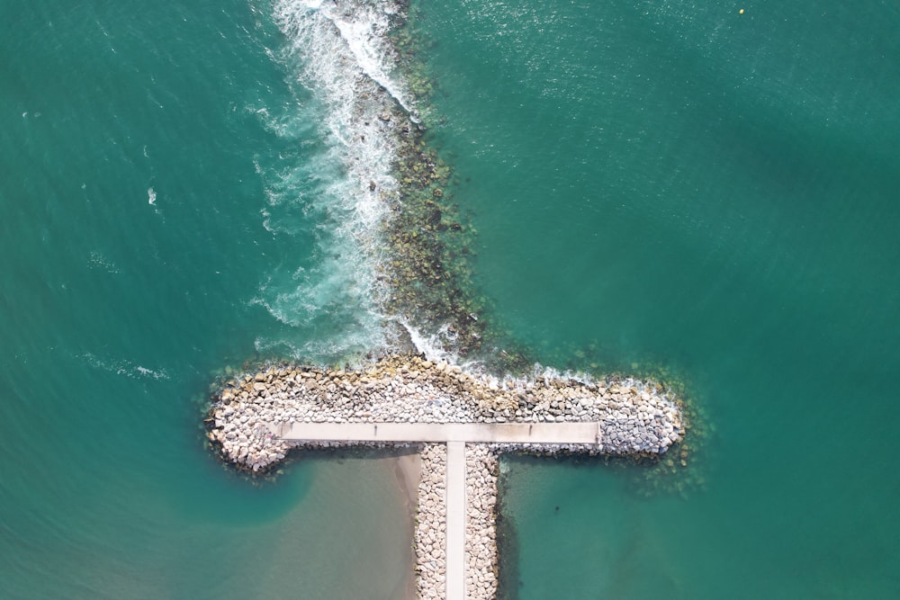 an aerial view of a pier in the ocean