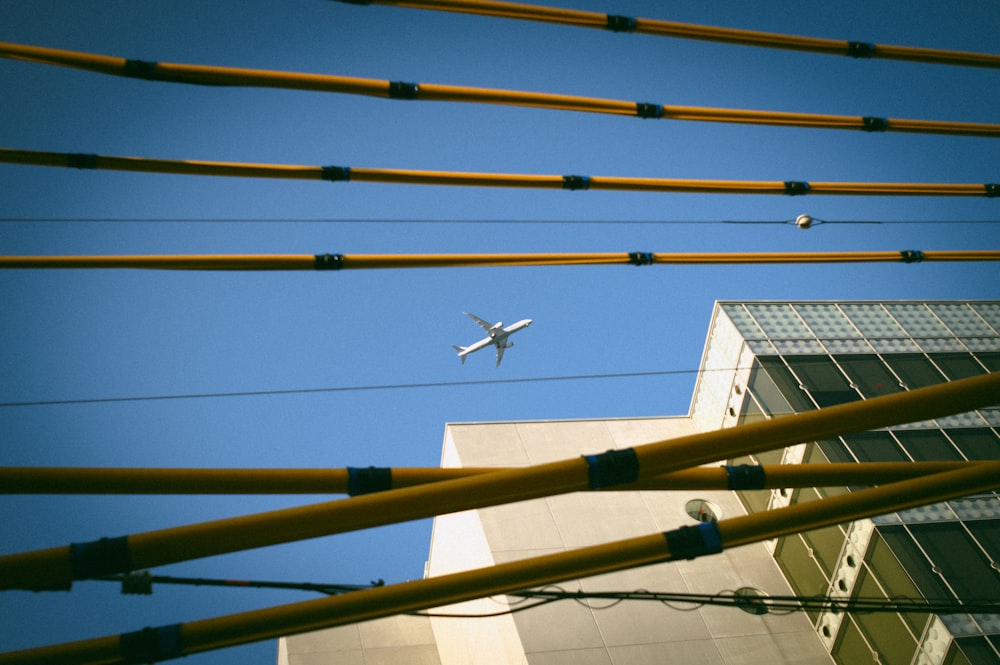 an airplane is flying over a building and power lines