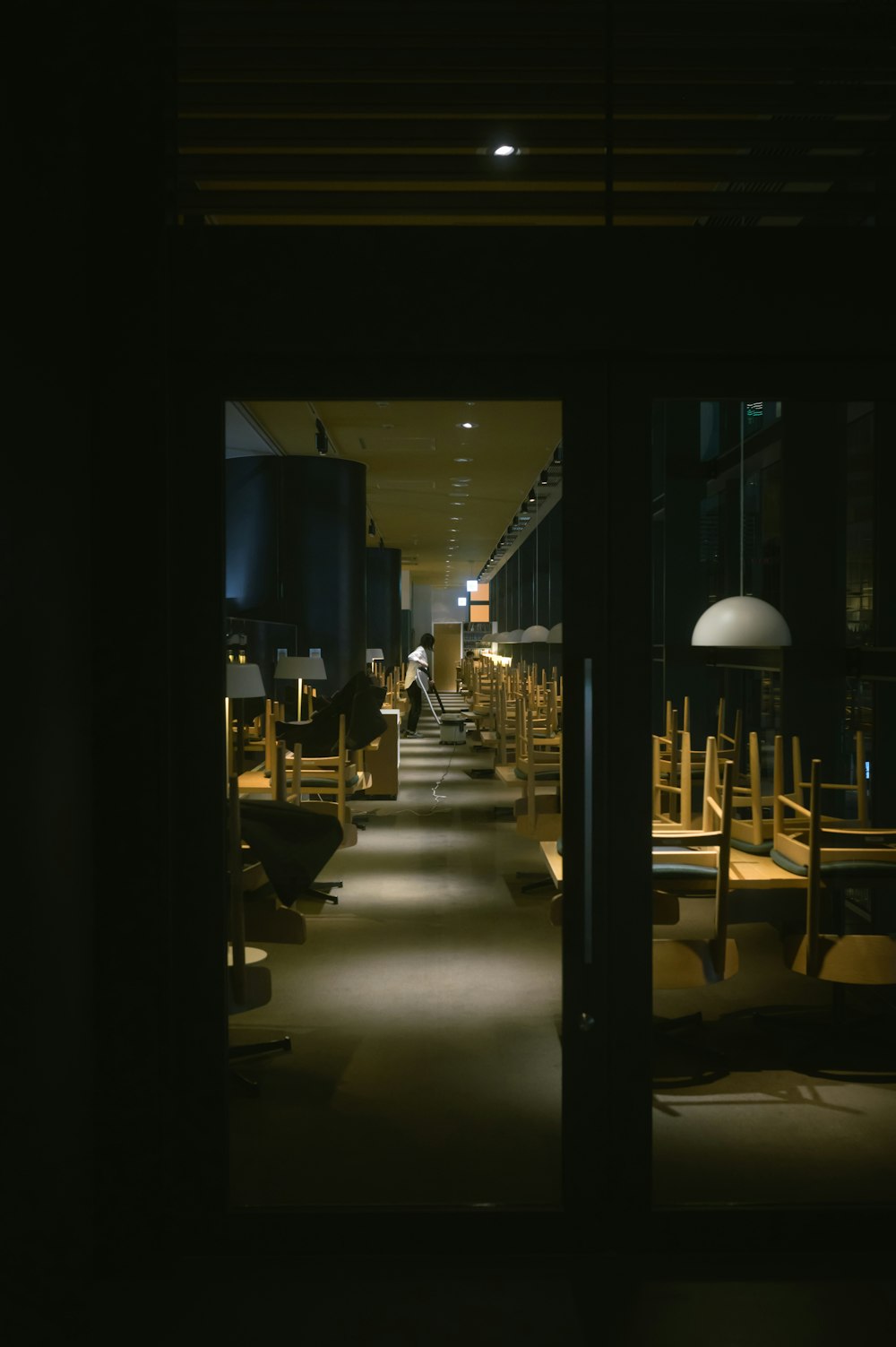 a dimly lit room with wooden tables and chairs