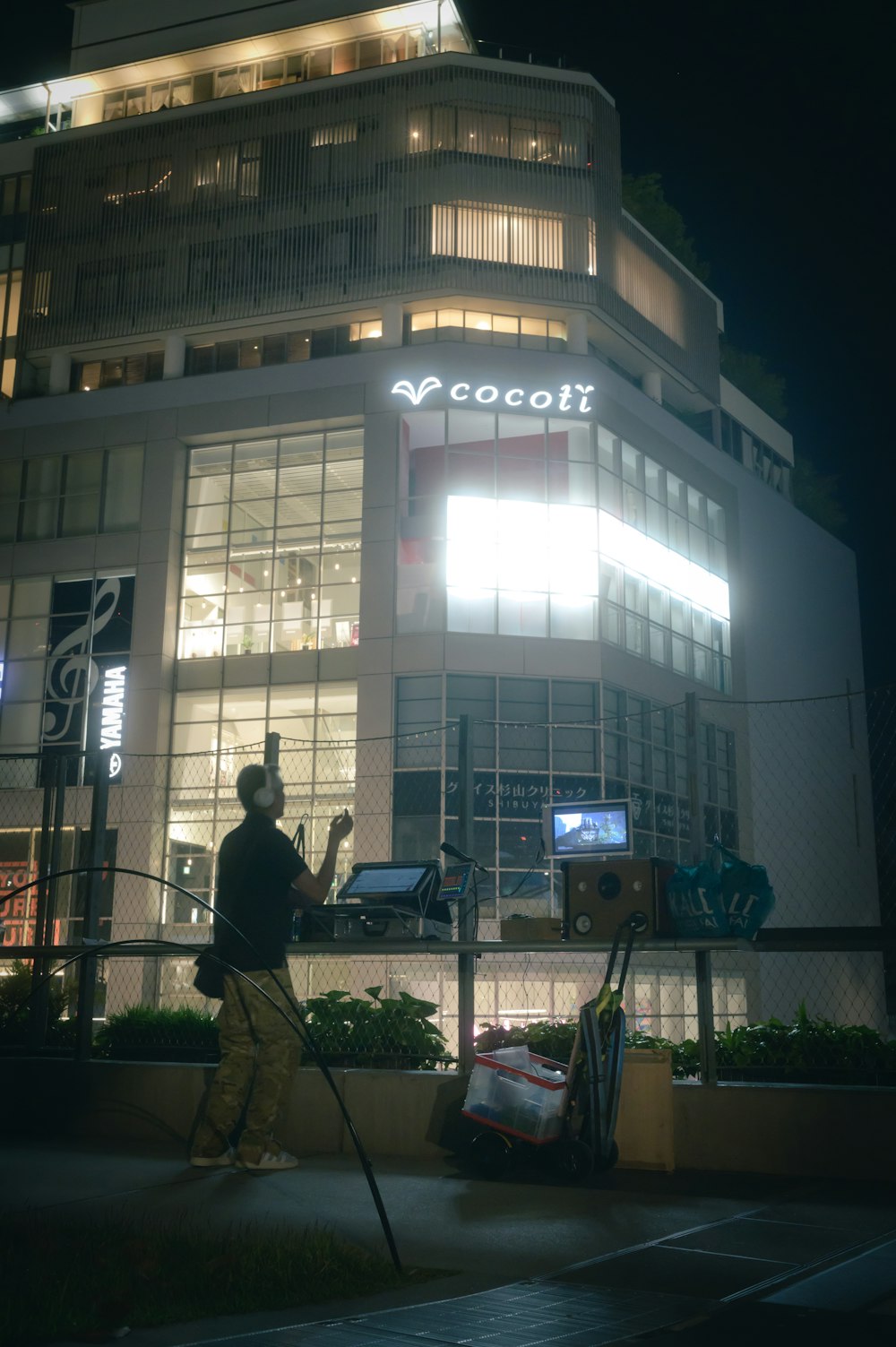 um homem parado em frente a um prédio à noite
