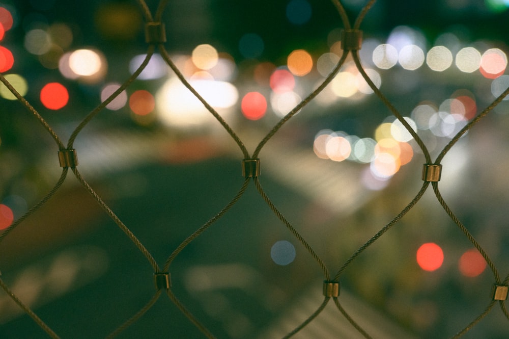 a close up of a chain link fence at night
