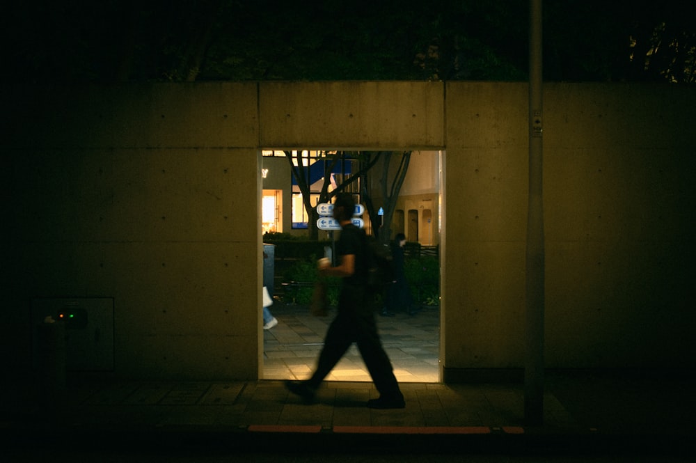 a person walking out of a building at night