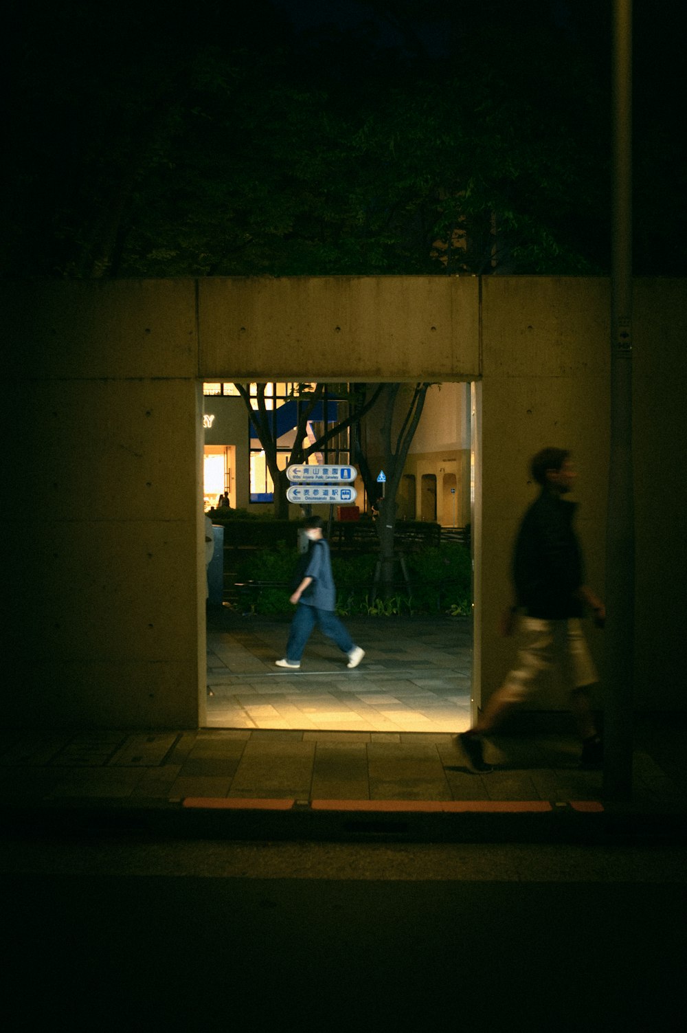 a couple of people walking down a street at night