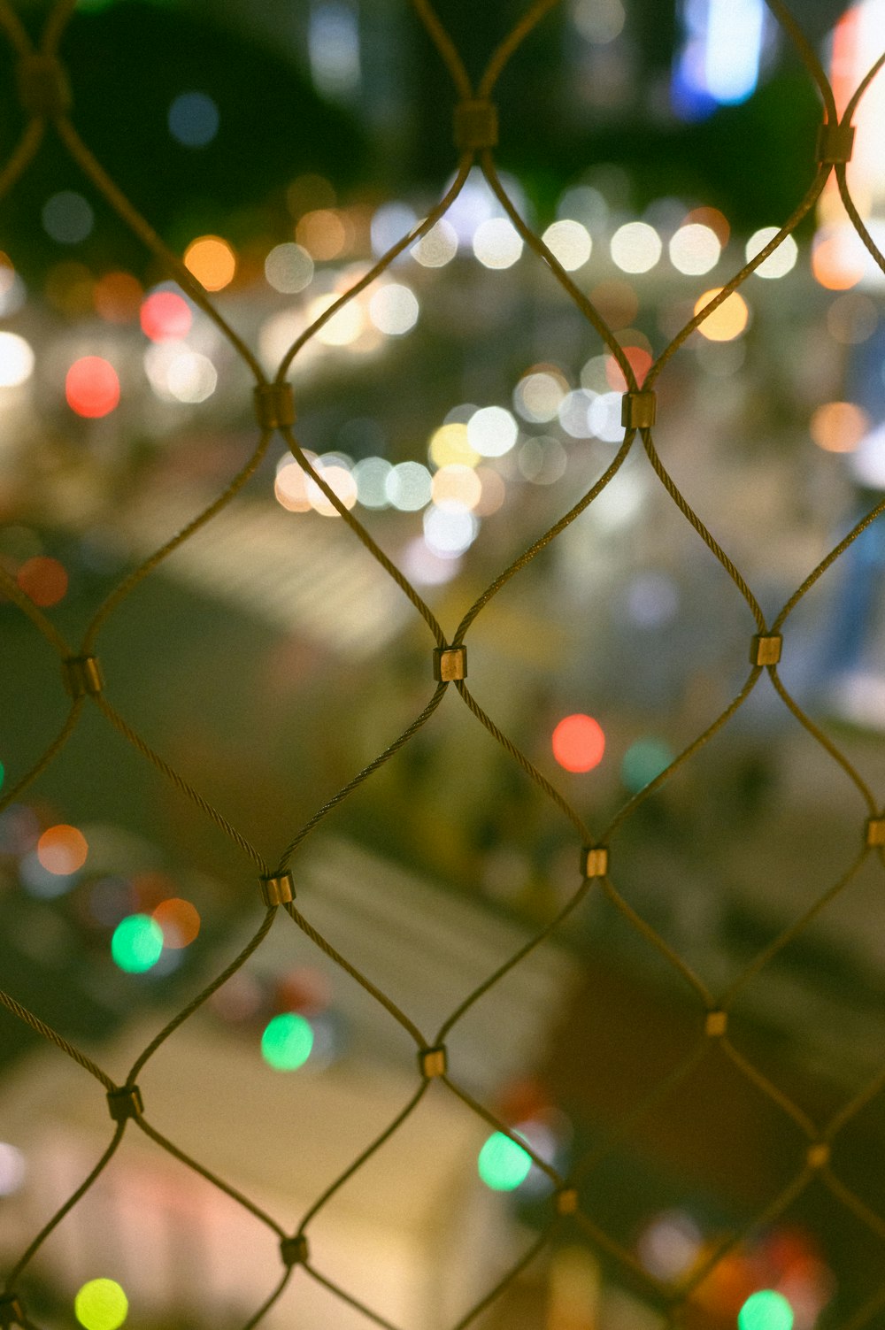 a close up of a chain link fence at night