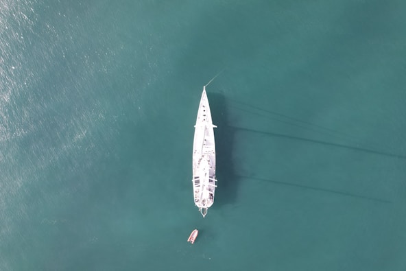 a white boat floating on top of a body of water
