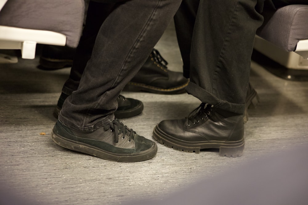 a pair of black shoes sitting on top of a bed