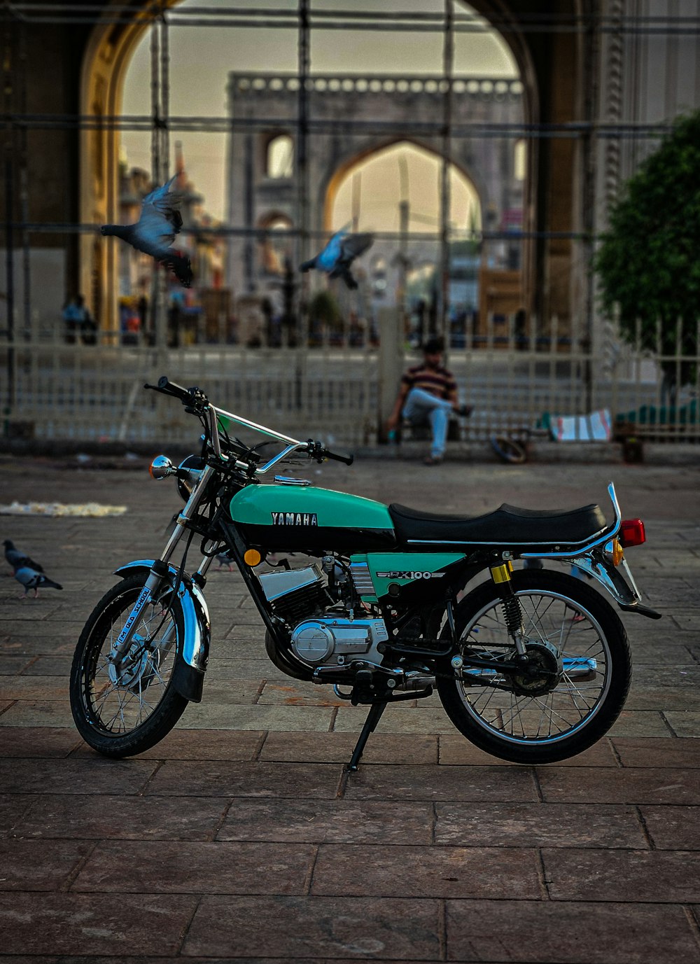 a blue and black motorcycle parked in front of a building