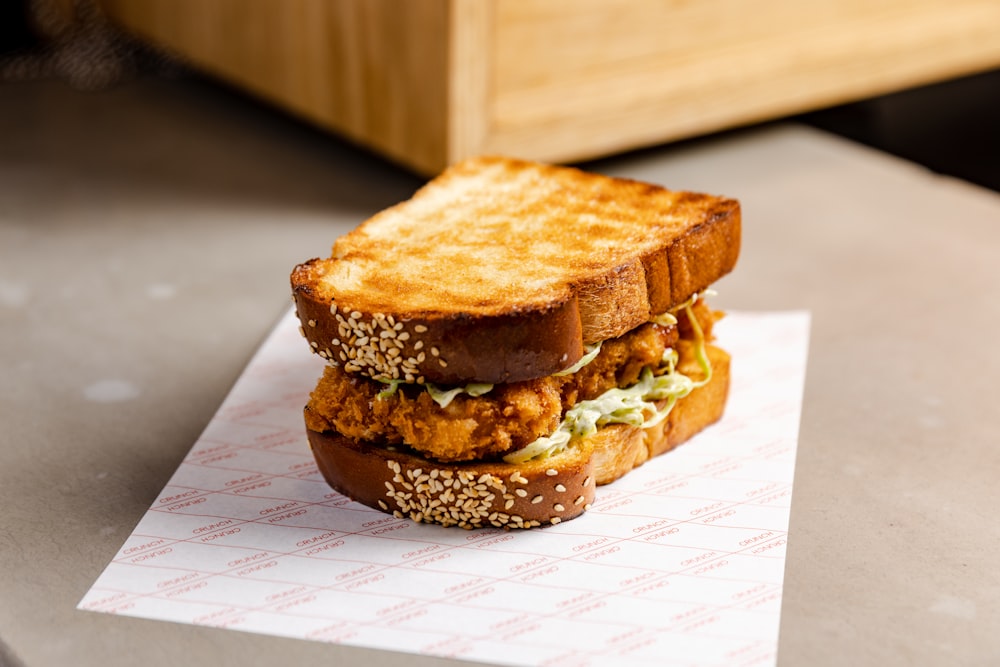 a chicken sandwich sitting on top of a piece of paper