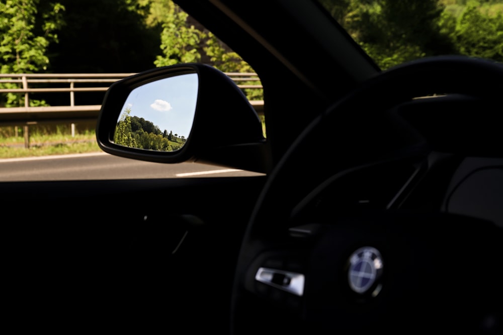 a car's view of a road through a rear view mirror