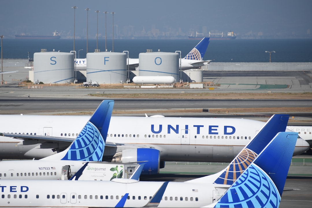 a bunch of airplanes that are on a runway, United Airlines jets at San Francisco International Airport (SFO)