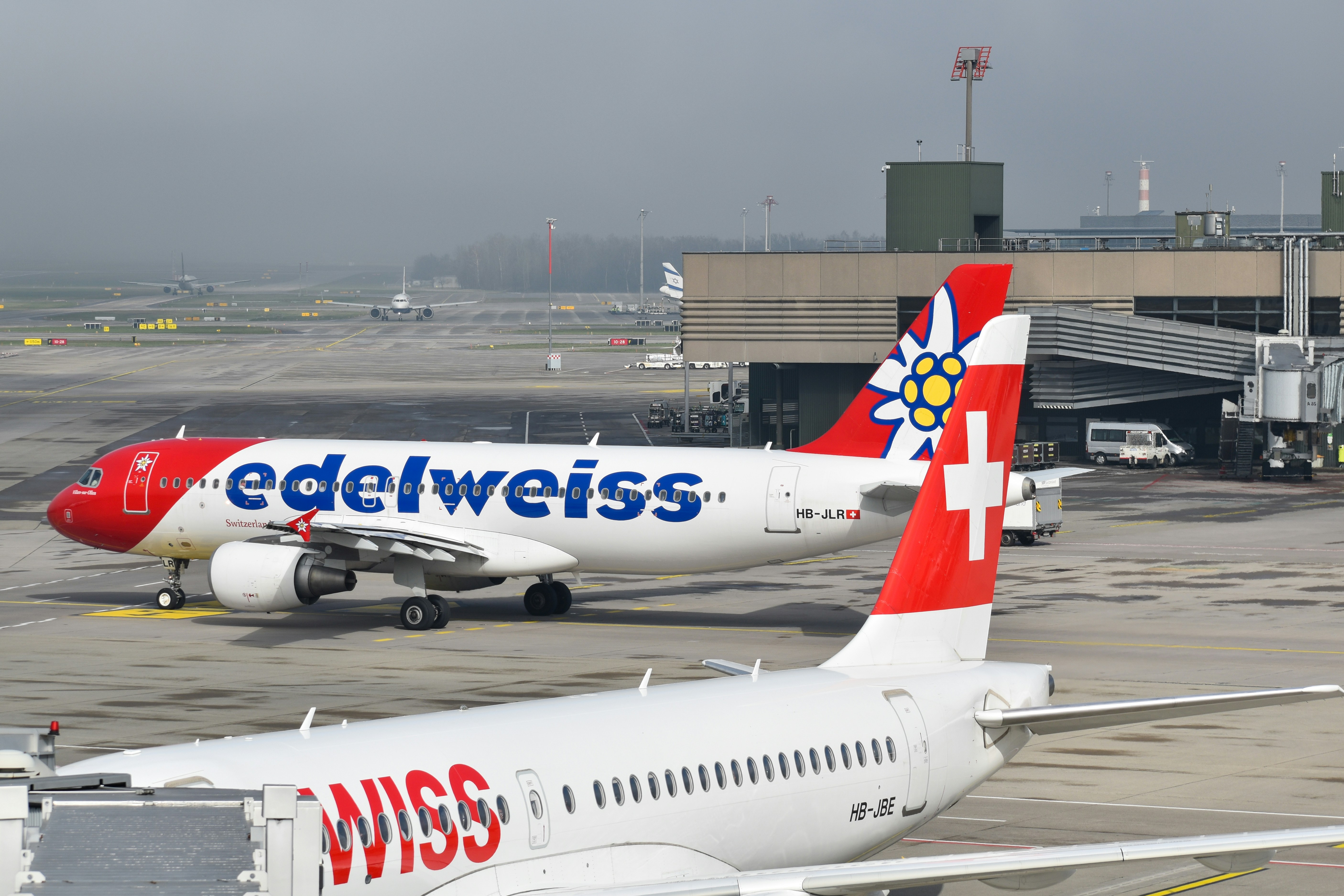 two airplanes are parked on the tarmac at an airport
