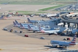 an airport filled with lots of airplanes parked on top of tarmac