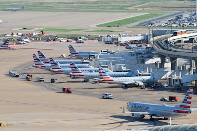 an airport filled with lots of airplanes parked on top of tarmac