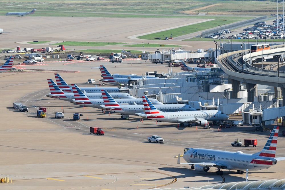 an airport filled with lots of airplanes parked on top of tarmac