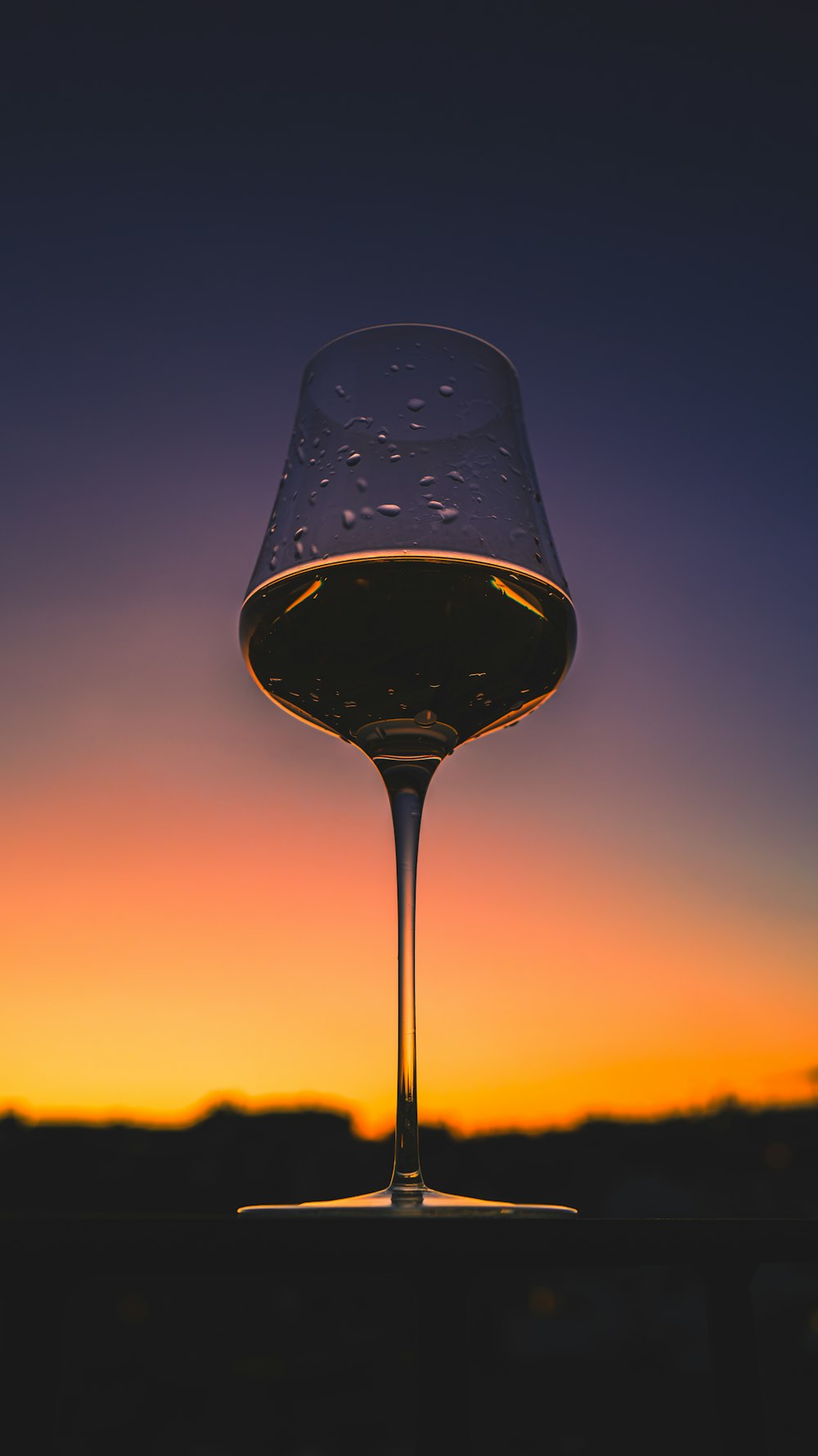 a glass of wine sitting on top of a table