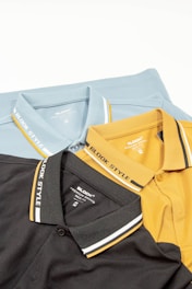 a group of three polo shirts sitting on top of each other