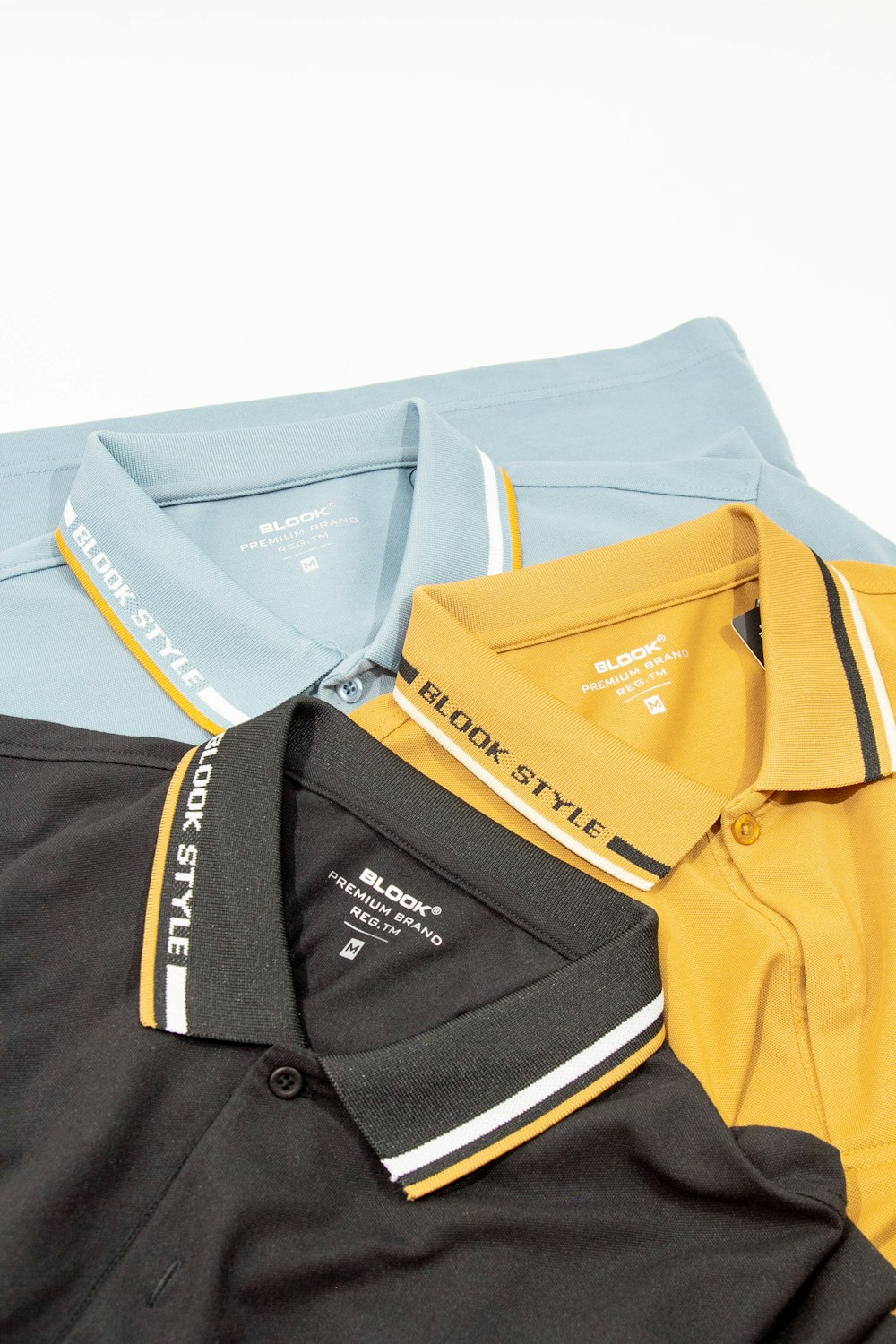 a group of three polo shirts sitting on top of each other