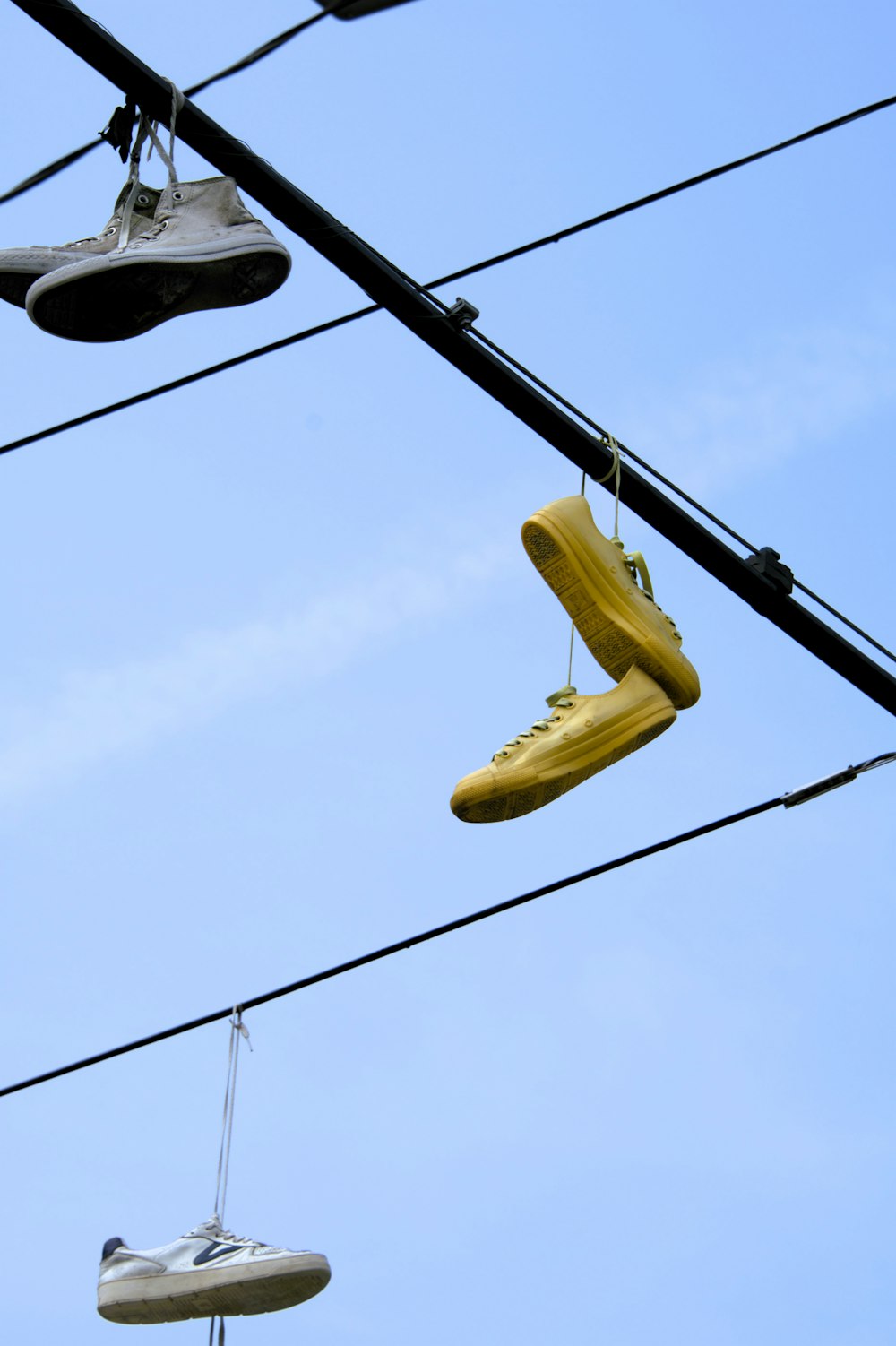 ein Paar gelbe Schuhe, die an einer Stromleitung hängen