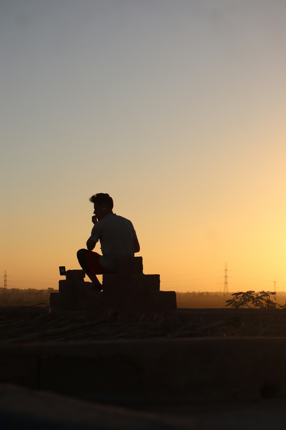 a man sitting on a bench at sunset