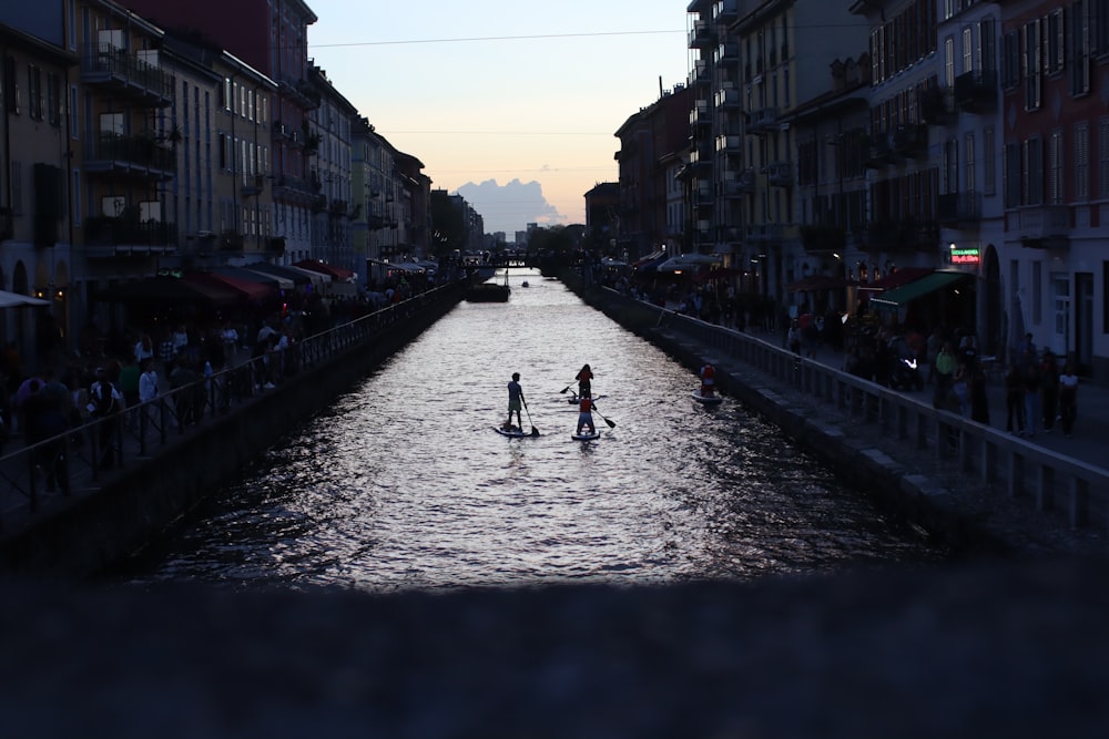 a group of people riding paddle boards down a river