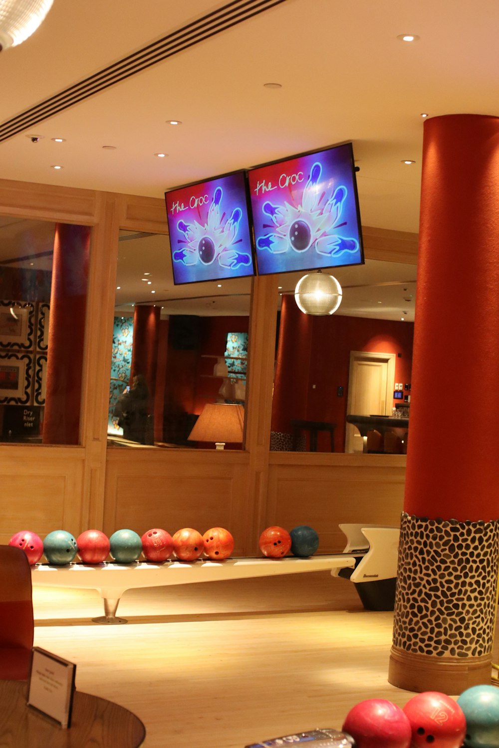 a bowling alley with bowling balls on the floor