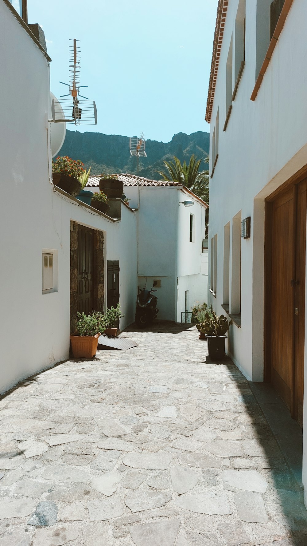 an alley way with a clock on the wall