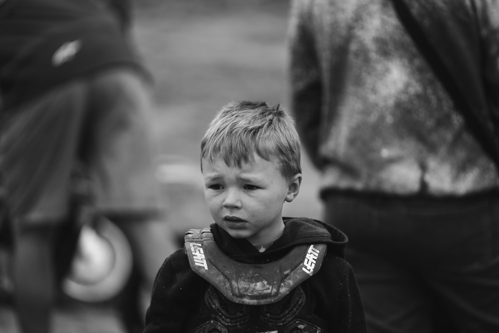 a young boy standing next to a horse