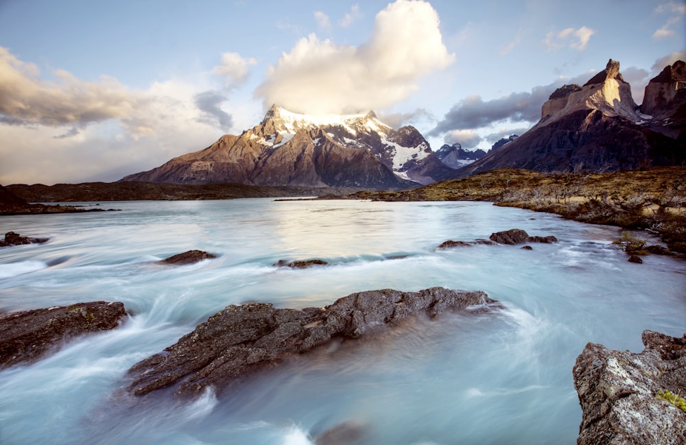 a mountain range in the distance with a body of water in the foreground