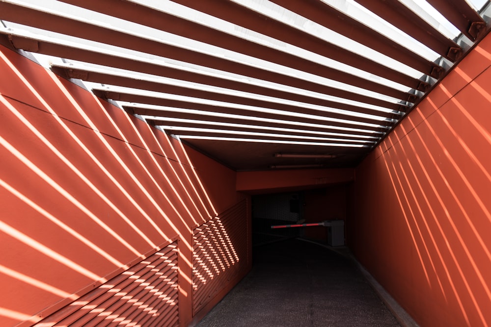 a hallway with a red wall and shadows on the wall