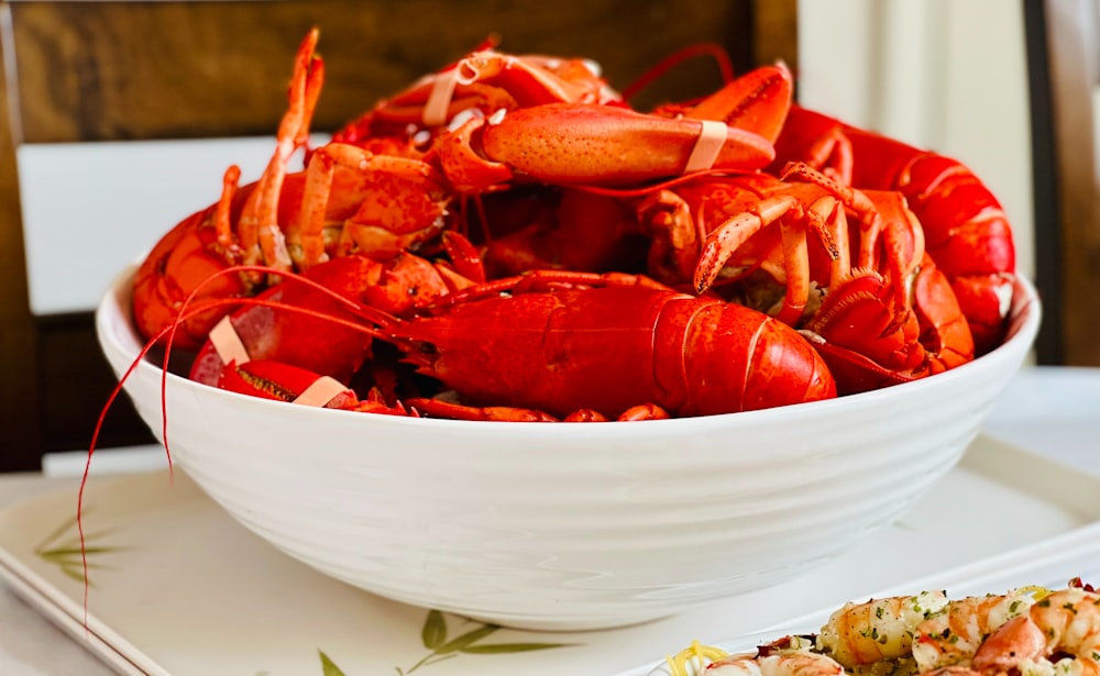 a bowl of cooked lobsters on a plate