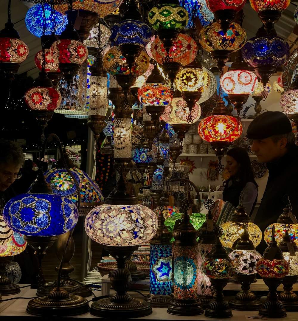 a man and a woman standing in front of a display of lamps