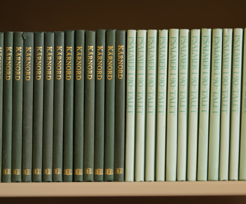 a row of books sitting on top of a white shelf