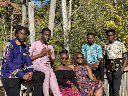 a group of people sitting next to each other on a bridge