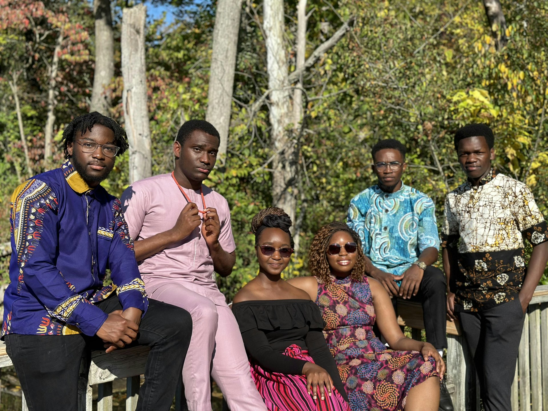 a group of people sitting next to each other on a bridge