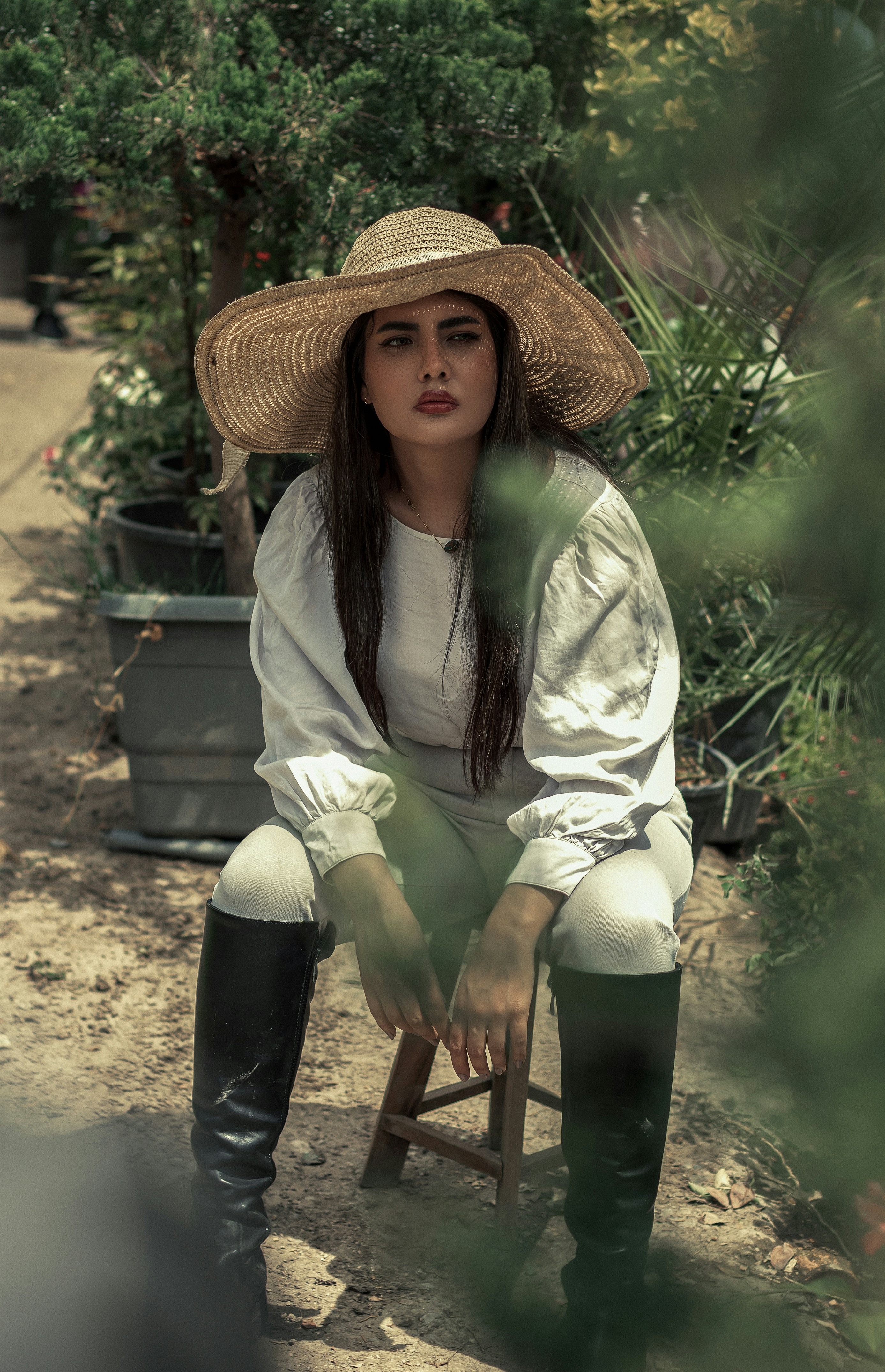 a woman sitting on a chair wearing a hat