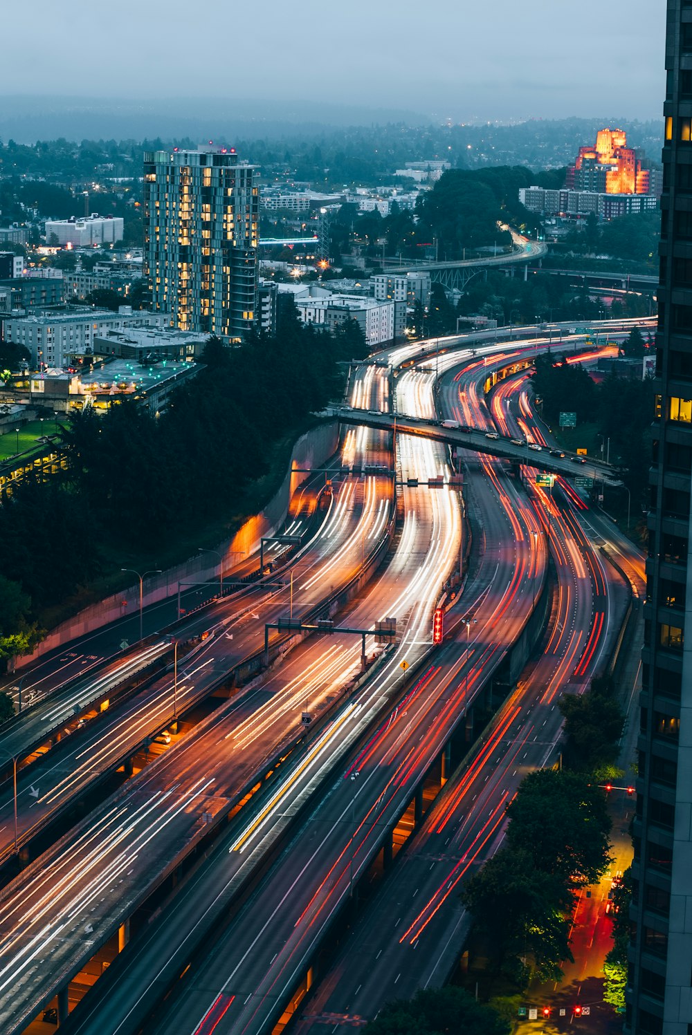 a city street filled with lots of traffic next to tall buildings